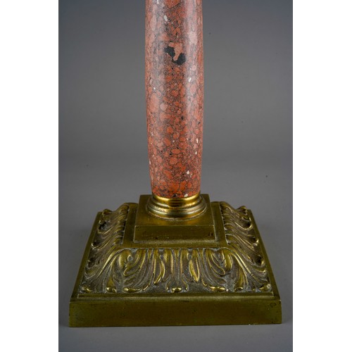 894 - An early 20th Century oil lamp with ruby glass wyvern twisted shade and reservoir, on mottled marble... 