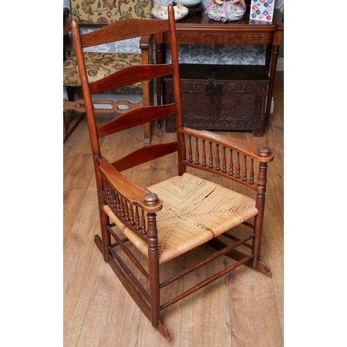 957 - A mahogany ladder back large rocking chair, balustrade arm supports, rope twist seat