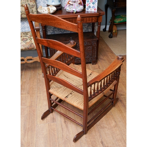 957 - A mahogany ladder back large rocking chair, balustrade arm supports, rope twist seat