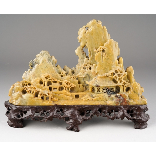 1000 - A carved Chinese soapstone ornament of a mountainous landscape on a scrolled base, height 13cm x wid... 