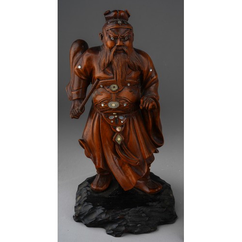 1004 - A Meiji period Japanese boxwood and inlaid okimono of a warrior, carved as standing on ebonised base... 