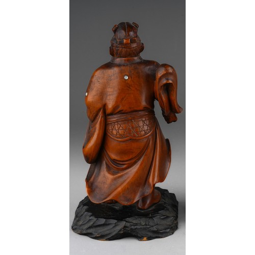 1004 - A Meiji period Japanese boxwood and inlaid okimono of a warrior, carved as standing on ebonised base... 