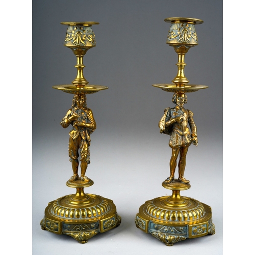 73 - A pair of late 19th century brass figural candlesticks, removable sconces the holders cast with foli... 