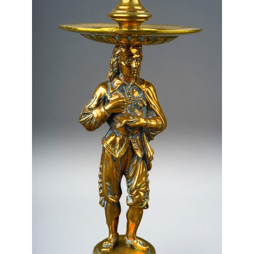 73 - A pair of late 19th century brass figural candlesticks, removable sconces the holders cast with foli... 