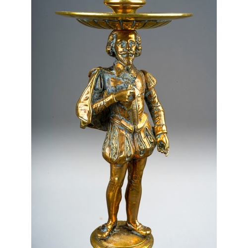 73 - A pair of late 19th century brass figural candlesticks, removable sconces the holders cast with foli... 