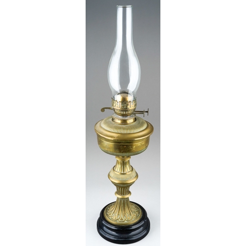 83 - A late Victorian brass based oil lamp, brass reservoir, fluted and reeded decoration, on a black gla... 