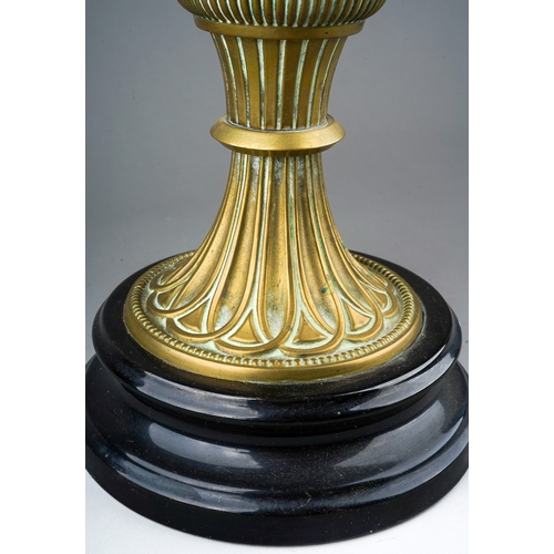 83 - A late Victorian brass based oil lamp, brass reservoir, fluted and reeded decoration, on a black gla... 