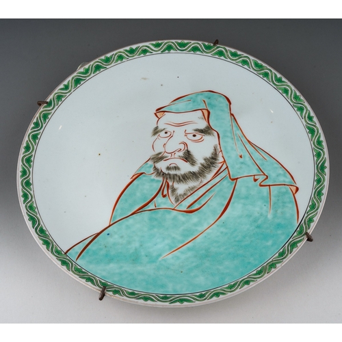 103 - A Japanese porcelain plate, enamelled with a green lotus and wavy line border and portrait of a man ... 