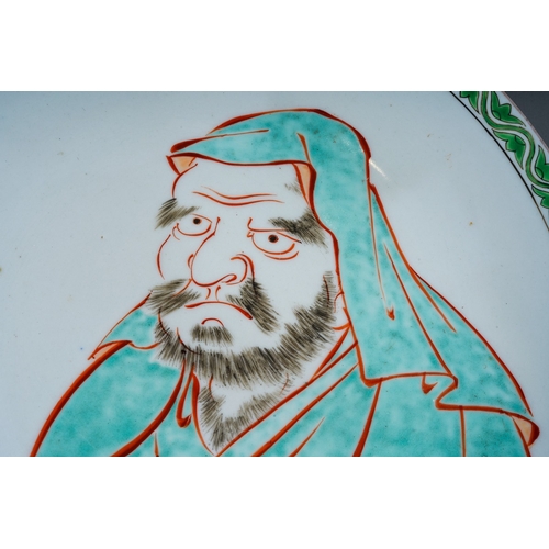 103 - A Japanese porcelain plate, enamelled with a green lotus and wavy line border and portrait of a man ... 