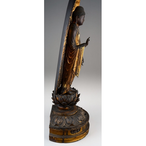 132 - An Edo period (1615-1868) lacquered giltwood figure of Amida Nyorai, glass urna, both hands in raigo... 