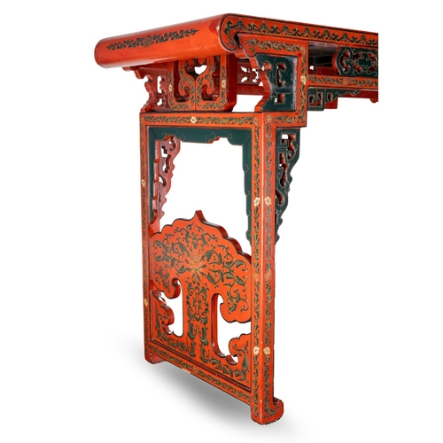 141 - A Chinese red lacquer carved altar table with a pierced frieze, the top decorated with mountainous l... 