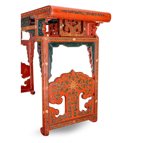 141 - A Chinese red lacquer carved altar table with a pierced frieze, the top decorated with mountainous l... 