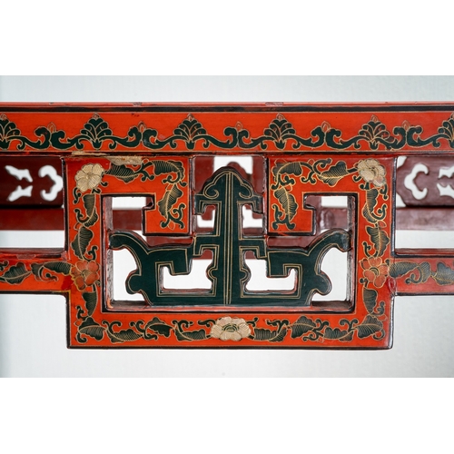 141 - A Chinese red lacquer carved altar table with a pierced frieze, the top decorated with mountainous l... 