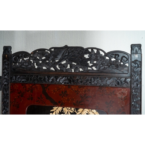 143 - A Japanese Meiji period shibayama two fold screen, fret tops above lacquer panels with applied carve... 