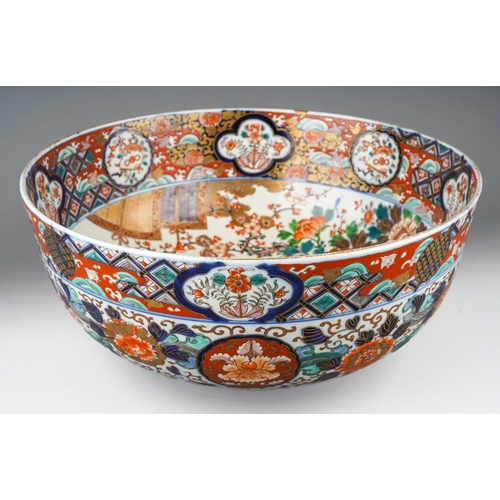 155 - A Japanese porcelain Imari punch bowl, the bowl interior painted with geisha and another figure in a... 