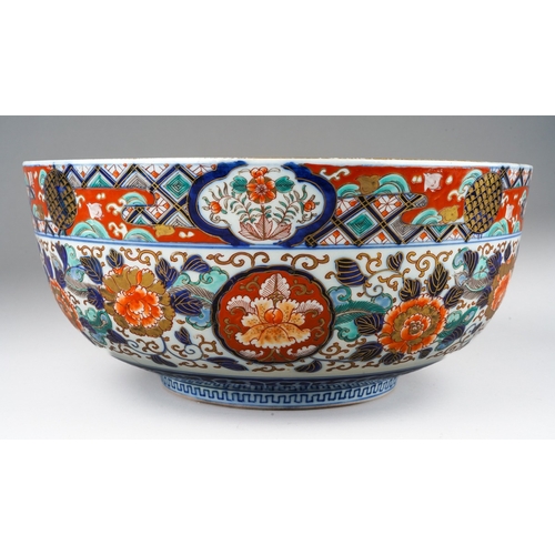 155 - A Japanese porcelain Imari punch bowl, the bowl interior painted with geisha and another figure in a... 