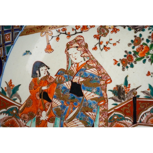 155 - A Japanese porcelain Imari punch bowl, the bowl interior painted with geisha and another figure in a... 