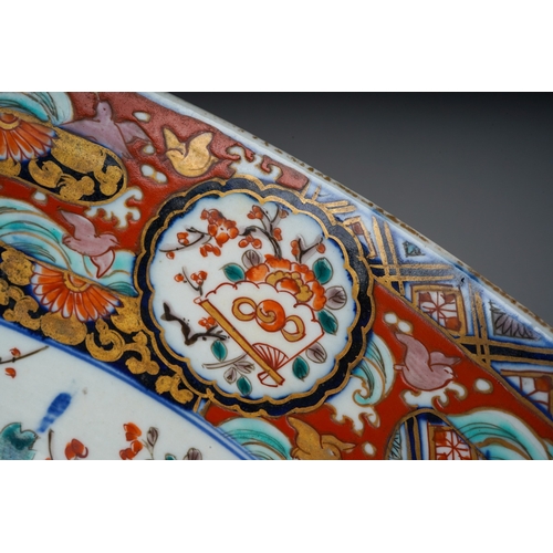 155 - A Japanese porcelain Imari punch bowl, the bowl interior painted with geisha and another figure in a... 
