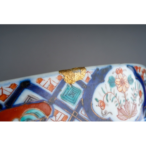 155 - A Japanese porcelain Imari punch bowl, the bowl interior painted with geisha and another figure in a... 