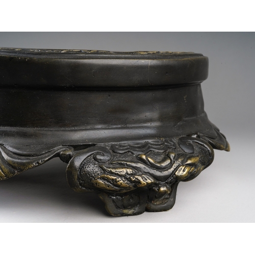 166 - A Chinese bronze stand, the top cast with a band of shallow relief scrolls and foliate decoration, t... 