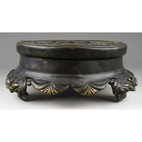 166 - A Chinese bronze stand, the top cast with a band of shallow relief scrolls and foliate decoration, t... 