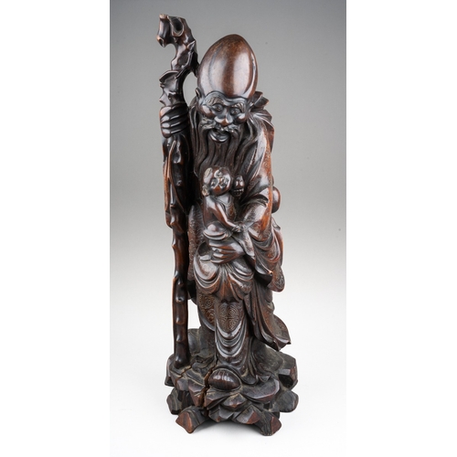 167 - A Chinese carved hardwood figure of a elder with a staff and holding a child , silver wire inlay, ca... 