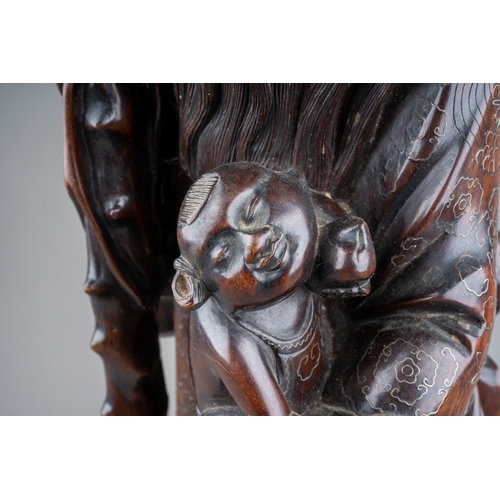167 - A Chinese carved hardwood figure of a elder with a staff and holding a child , silver wire inlay, ca... 
