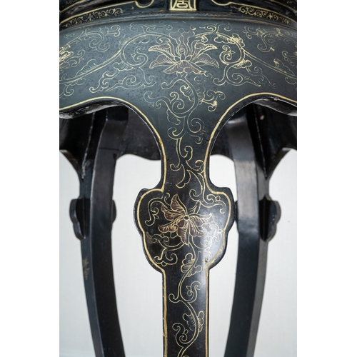 169 - A Chinese black lacquered and gilt papier mache display table, of circular form, wavy apron, on five... 
