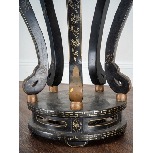 169 - A Chinese black lacquered and gilt papier mache display table, of circular form, wavy apron, on five... 