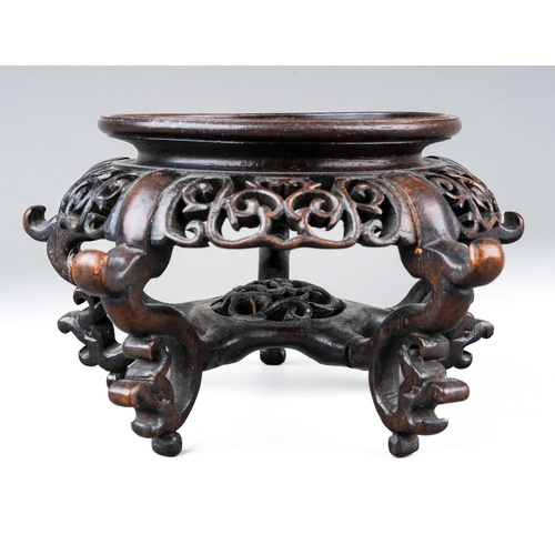 207 - A small Chinese carved and pierced hardwood stand, on five ornately scrolled legs linked by a pierce... 