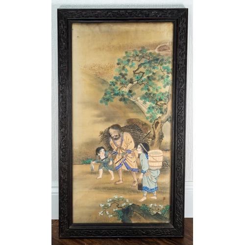 214 - A Japanese painting on silk of a man carrying a bundle of sticks with two children by his side, in a... 