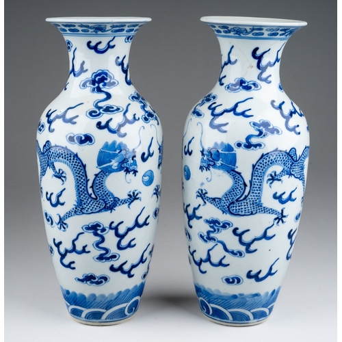 219 - A pair of Chinese porcelain blue and white baluster vases, each decorated with two five clawed drago... 