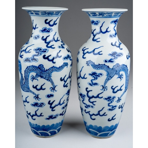 219 - A pair of Chinese porcelain blue and white baluster vases, each decorated with two five clawed drago... 