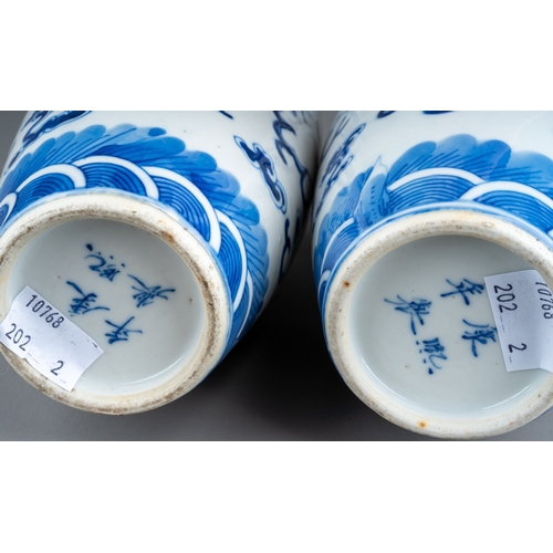 219 - A pair of Chinese porcelain blue and white baluster vases, each decorated with two five clawed drago... 