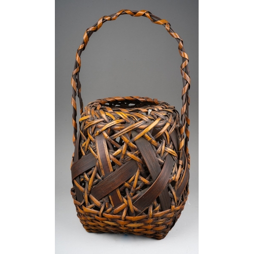 251 - A Japanese woven wicker Ikebana basket with carrying handle, the basket of circular form, height 42c... 