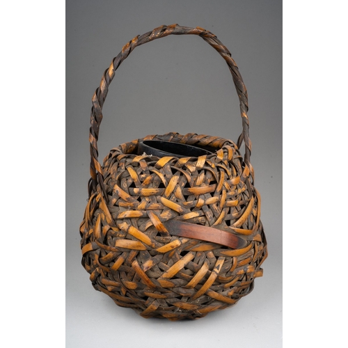 252 - A Japanese woven wicker Ikebana basket with carrying handle, of circular form, height 28cm