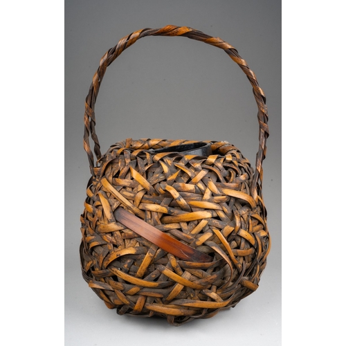 252 - A Japanese woven wicker Ikebana basket with carrying handle, of circular form, height 28cm