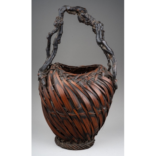 255 - A Japanese woven wicker Ikebana basket with root handle, the basket of oval form, height 44cm