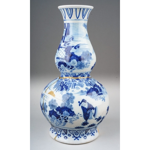 266 - A Dutch Delft pottery double gourd blue and white vase decorated in the Chinoiserie style, gilding t... 