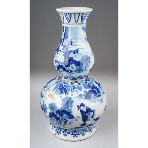 266 - A Dutch Delft pottery double gourd blue and white vase decorated in the Chinoiserie style, gilding t... 