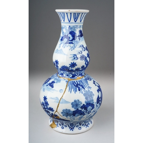 266 - A Dutch Delft pottery double gourd blue and white vase decorated in the Chinoiserie style, gilding t... 