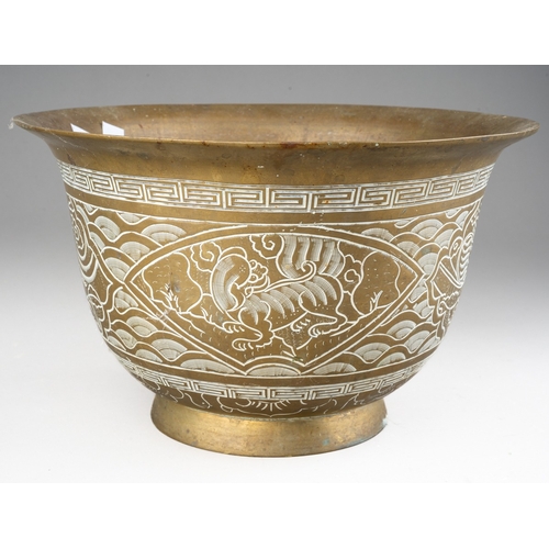 284 - A Chinese brass jardiniere, the exterior decorated with dragons and waves, cast dragon and six chara... 