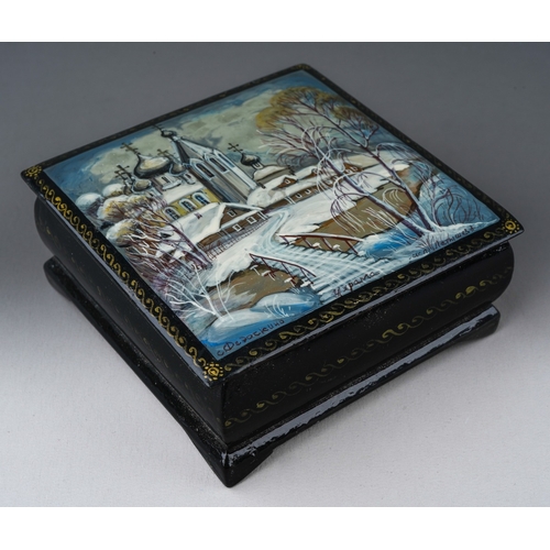 302 - A late 20th century Russian square lacquer box, painted to the hinged lid with a snowy landscape, be... 