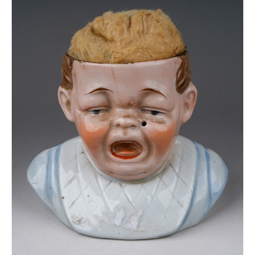 308 - A late 19th century Continental porcelain bust in cushion modelled as a crying boy, lacking fabric c... 