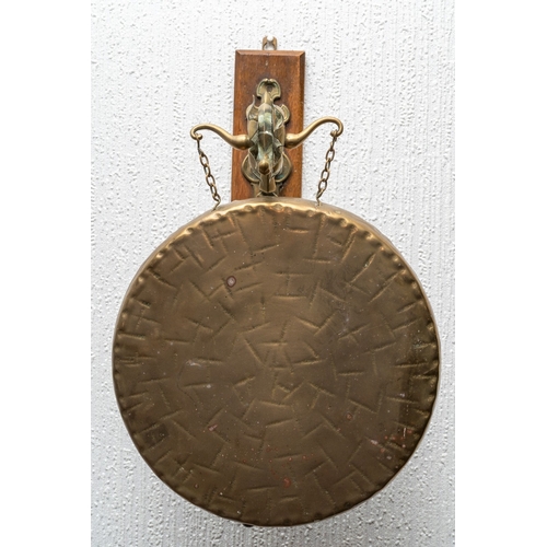 315 - A late Victorian wall hanging dinner gong, oak wall mount with gothic and foliate arm, 28cm diameter... 