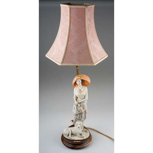 317 - A Dear Studio figural table lamp, with painted resin elegant lady with a dog at her feet, on a circu... 