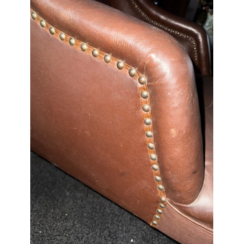 958 - A Victorian brown rexine upholstered easy chair, bolster style headrest, sloped arms, on walnut legs... 