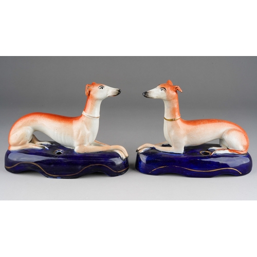 18 - A pair of 19th Century Staffordshire quill holders modelled as recumbent greyhounds on navy oval bas... 