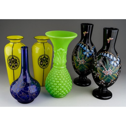 61 - Collection of Victorian glass to include a pair of black enamel vases, yellow vases and large green ... 