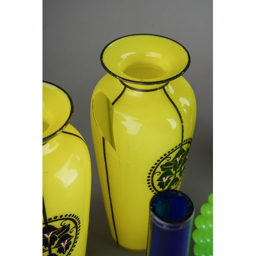 61 - Collection of Victorian glass to include a pair of black enamel vases, yellow vases and large green ... 